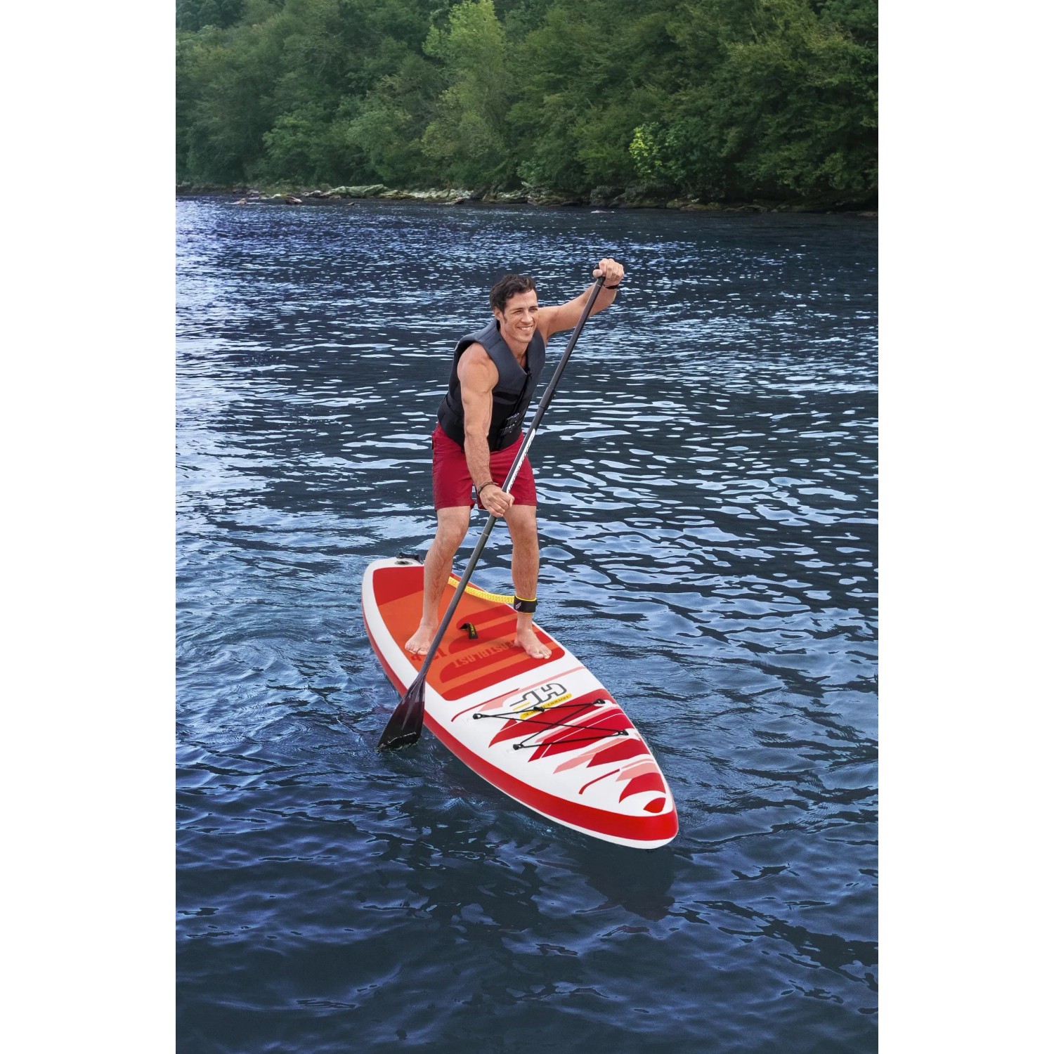 Mann auf Bestway Hydro-Force SUP Fast Touring Board. Rot-weißes Stand Up Paddle Board auf dem Wasser.