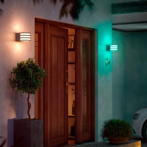 Smarte Philips Hue Lucca Wandleuchte mit Farbwechsel, montiert an einer Hauswand.