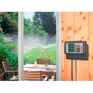 Gardena Classic 4030 Bewässerungssteuerung mit Garten im Hintergrund.