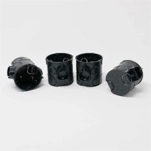 Vier schwarze, runde EGB UP Schalterdosen aus Kunststoff mit Ausbrechöffnungen für die Elektroinstallation.