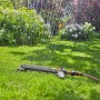 Gardena Rasensprenger Aqua Zoom M 250: Viereckregner bewässert Rasenfläche im Garten.
