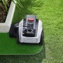 Ecovacs Mähroboter Goat O1200 auf Rasen, weiß-schwarz, mit Kantenschneider.