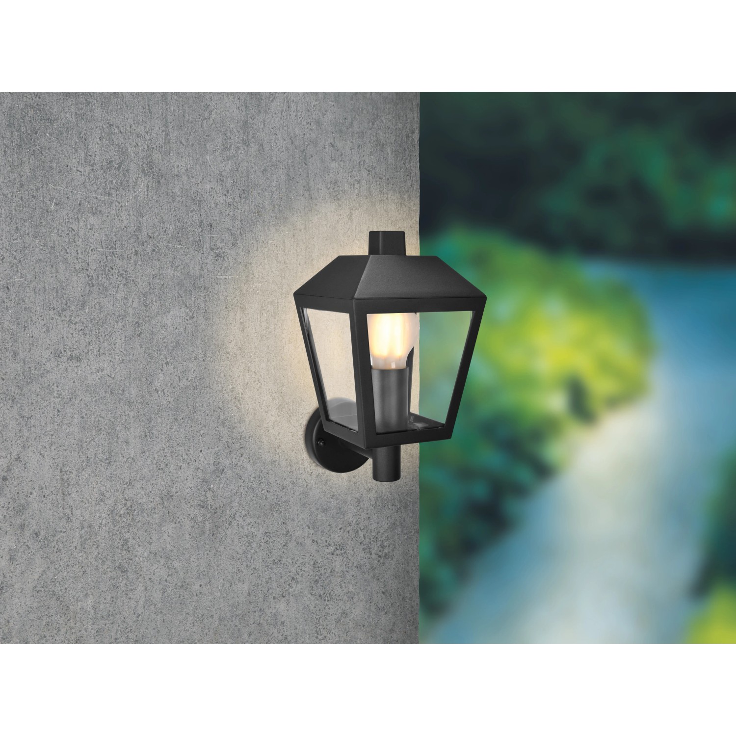 Schwarze Außenwandleuchte Vigevano aus Aluminium-Druckguss mit E27 Fassung an grauer Wand.