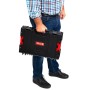 Schwarzer PROREGAL QBRICK Werkzeugkasten Pro Toolbox mit rotem Verschluss wird von einer Person getragen.