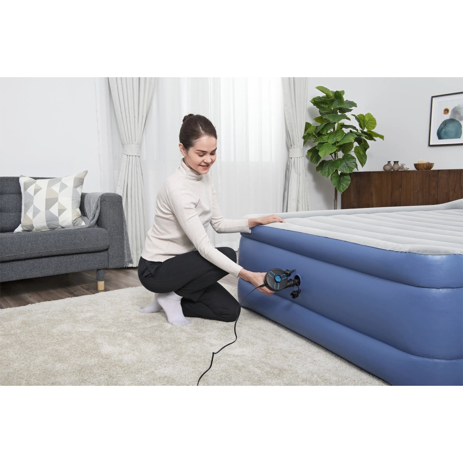 Frau pumpt Luftmatratze mit Bestway PowerTouch Elektropumpe auf.