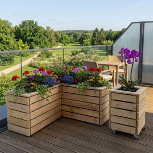 HolzFee Pflanzkasten Linea aus Lärche, L-förmig, mit bunten Blumen auf Balkon. Ein weiterer Blumenkasten auf Rollen.