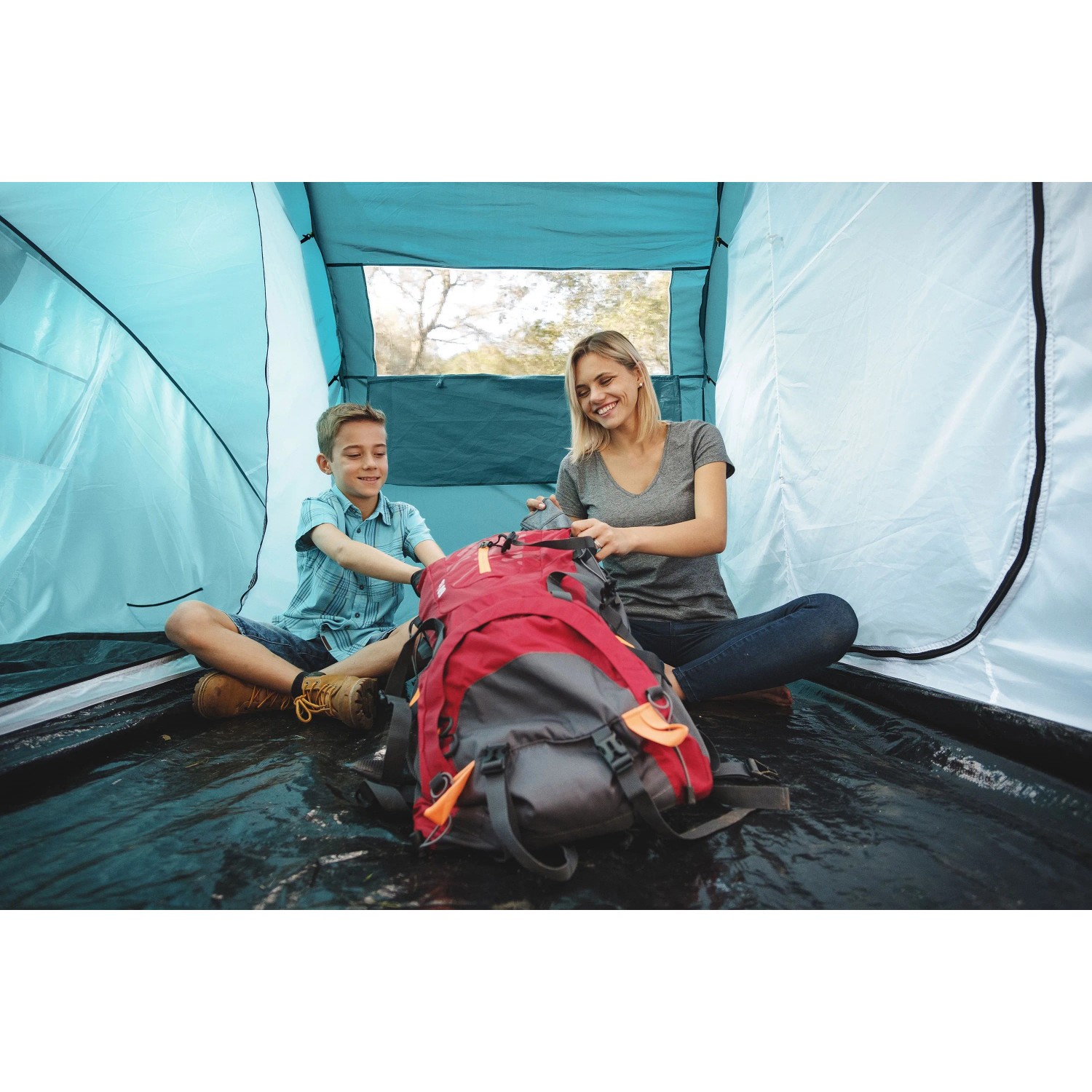 Pavillo Family Ground 4 Zelt: Mutter und Sohn packen Rucksack im Campingzelt.
