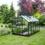 Schwarzes Halls Gewächshaus Popular 106 mit Glas auf Rasenfläche im Garten.
