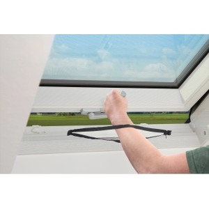 Anthrazitfarbenes Insektenschutznetz am Dachfenster mit Reißverschluss wird bedient.