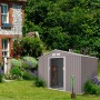 Helles, graues Hattoro S200 Metall Gerätehaus mit Satteldach im Garten, Tür offen.