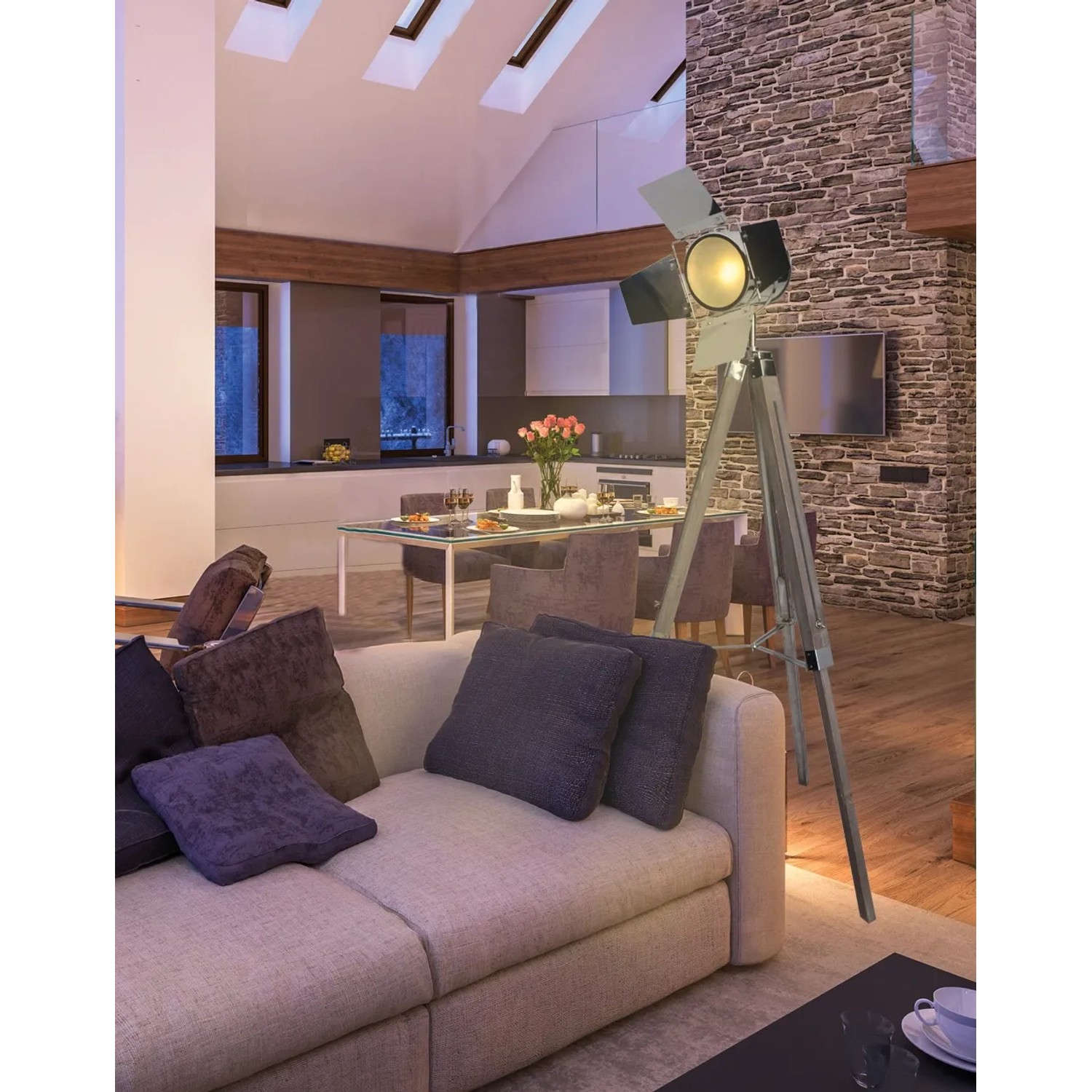 Näve Stehleuchte Dreibein Holly Natur dunkel im Wohnzimmer. Design-Stehlampe mit Holzgestell und silbernem Lampenschirm.
