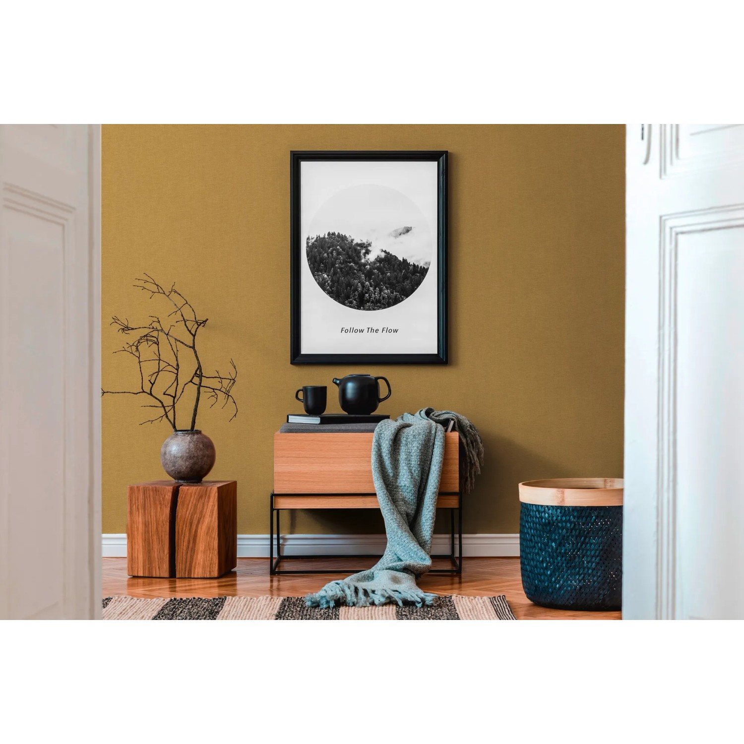 Strukturiertes, matt gelbes Uni-Vliestapetenmuster im Wohnraum mit Deko.