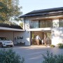 Anker Solix Solarbank mit Power Dock, Solarpanelen, E-Auto und Familie vor modernem Haus. Balkonkraftwerk.