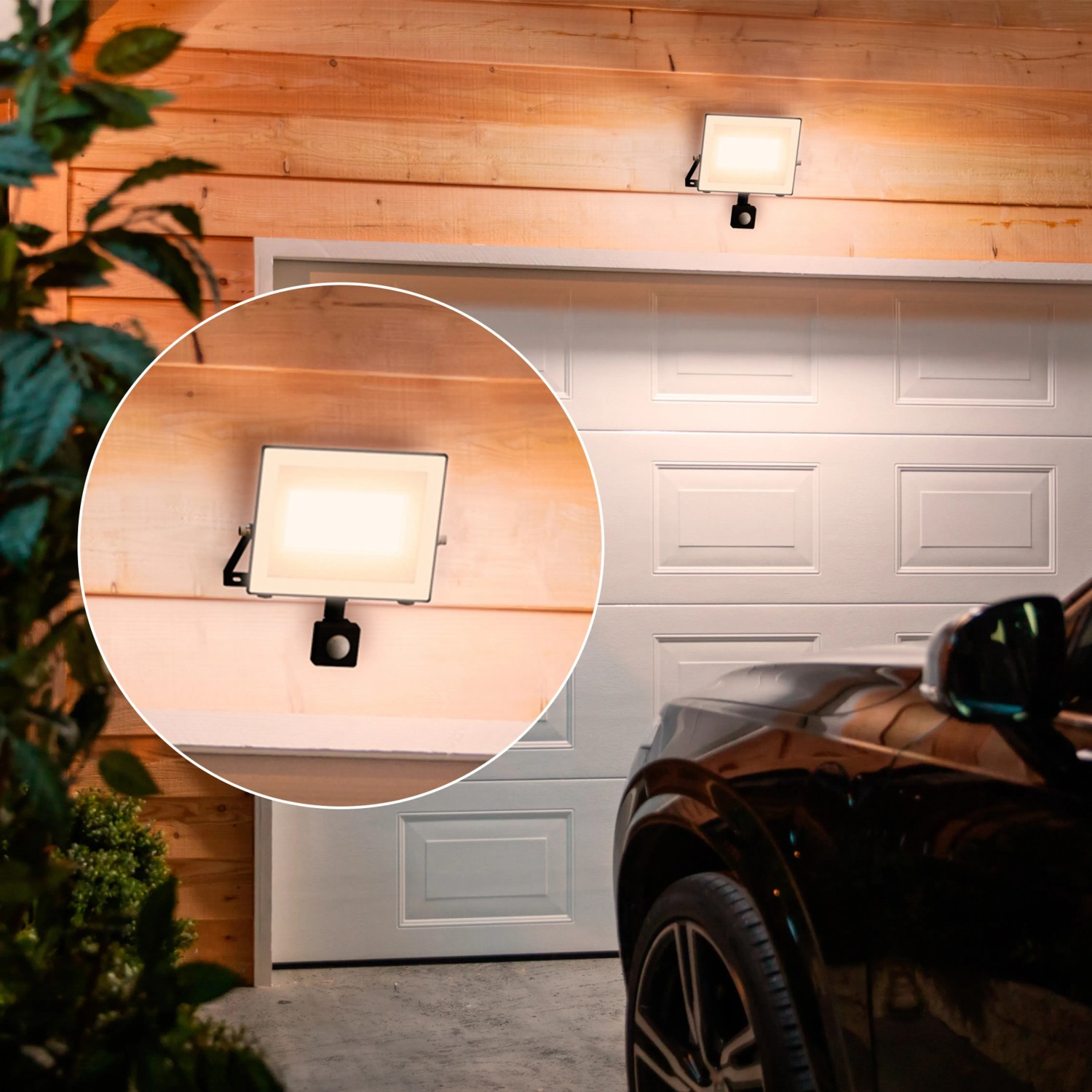 Philips Lois LED-Außenstrahler mit Sensor, 3000K, 4450lm, anthrazit an Garagenwand.