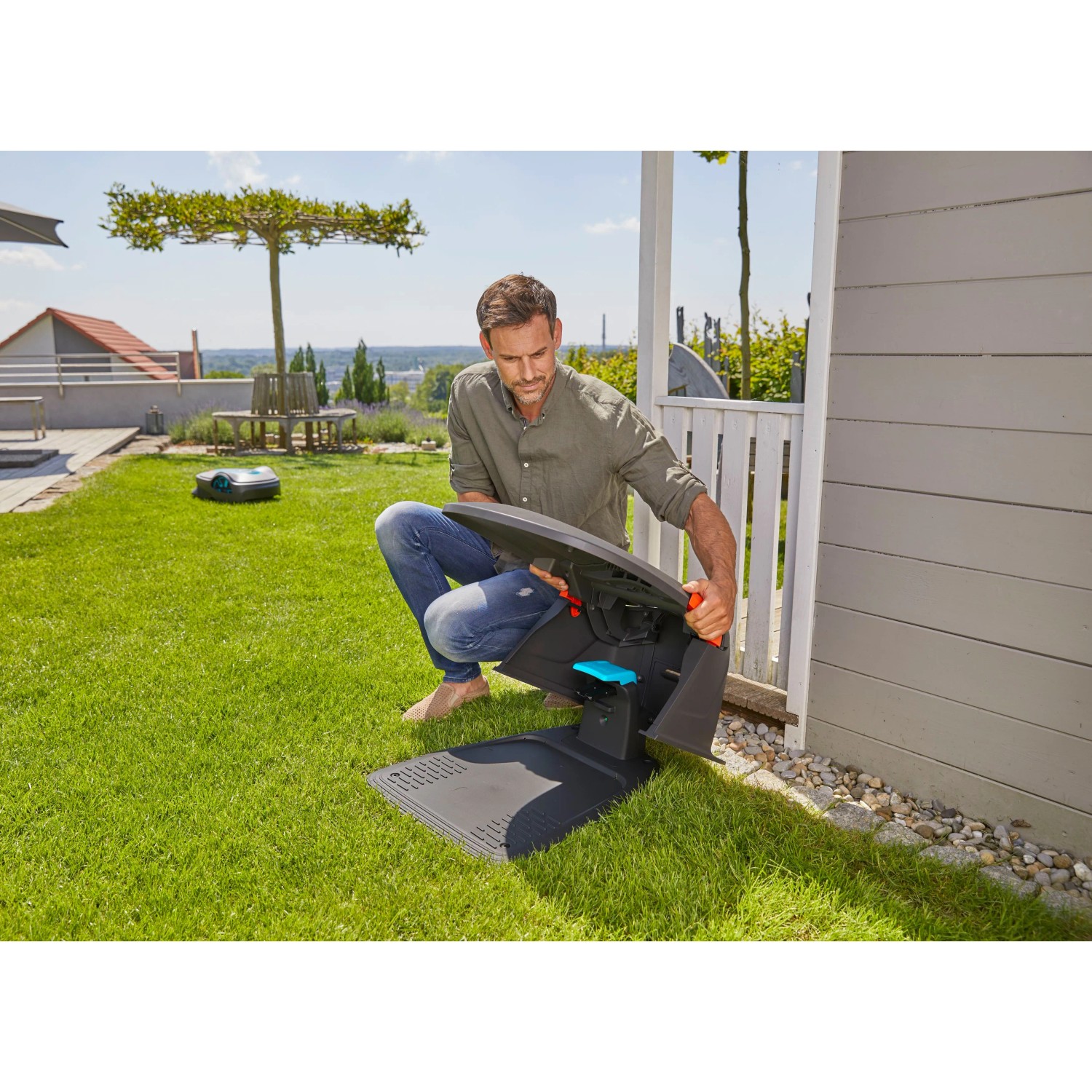 Gardena Garage für Sileno city/life Mähroboter: Mann öffnet Dach für Zugang. Schutz vor Wetter.