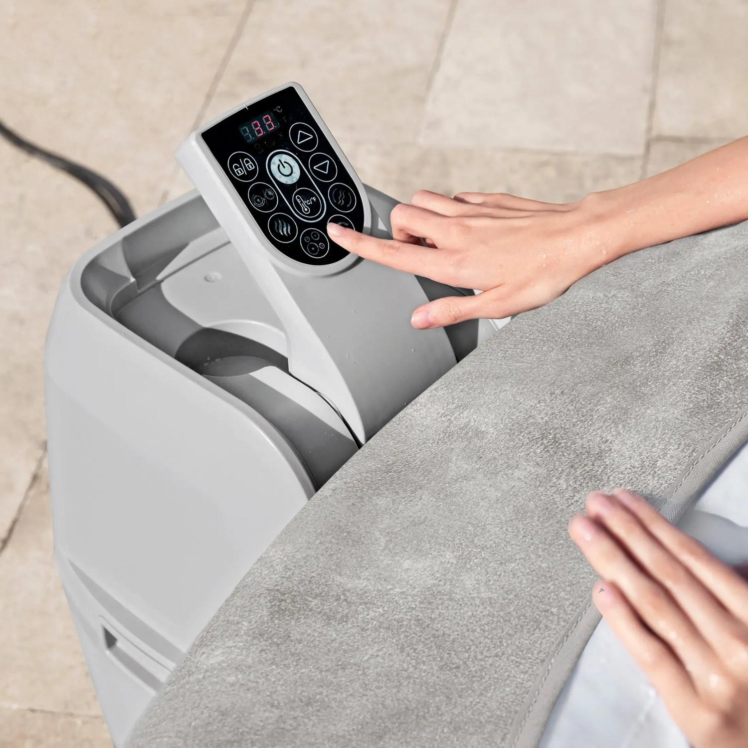 Detailaufnahme: Bedienfeld des Bestway Lay-Z-Spa Miami Beach AirJet Whirlpools mit Hand, die eine Funktion auswählt.