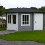 Graues Alpholz Gartenhaus Rhein mit Walmdach und Anbaudach im Garten.