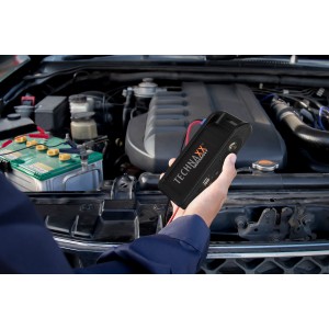 Technaxx TX-218 Schnellstartsystem in Aktion vor einem Motorraum. Starthilfe für Auto & Motorrad.