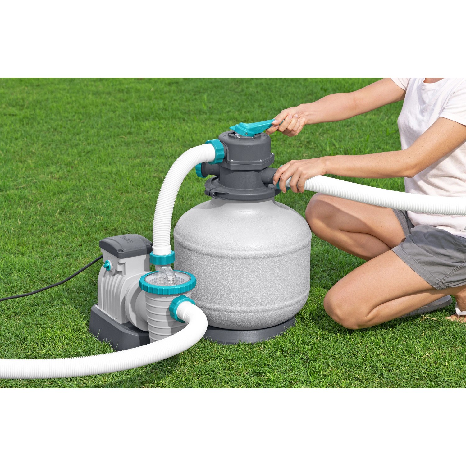 Bestway Sandfilteranlage für Stahlrahmen Pool, verbunden mit Schläuchen und bedient von einer Person.