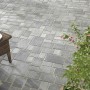 Verlegte, graue Mehrformat-Pflastersteine Encanto Beton Antik mit antikem Finish und Pflanze.