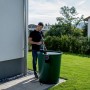 Mann nutzt Metabo Akku-Tauchpumpe TPF 18 LTX 2200 zur Gartenbewässerung aus Regentonne.