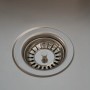 Detailaufnahme: Korbventil der Respekta Glasspüle New York, Spüle aus Glas in Weiß.