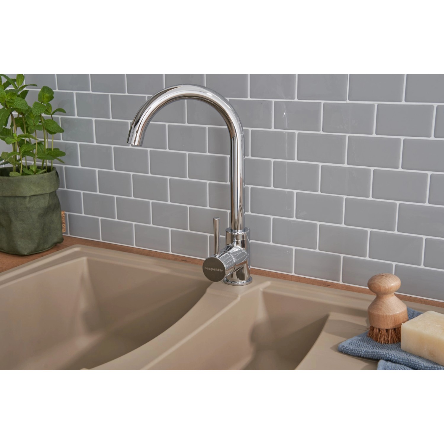 Respekta Mineralite Einbauspüle Boston, 100x50 cm, Sandbeige. Granitspüle mit Armatur vor grauer Wand.