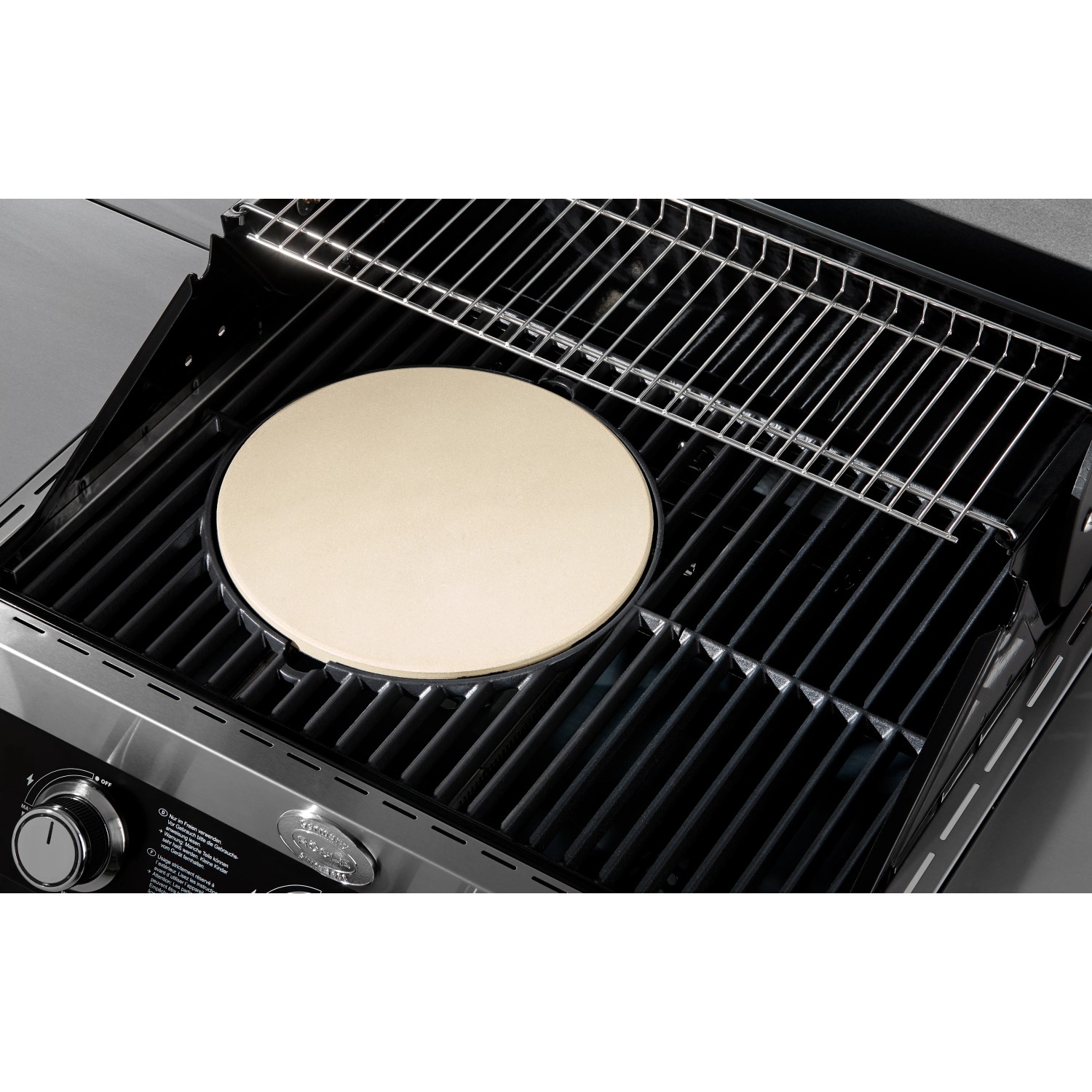 Rösle Pizzastein Vario Ø 30 cm aus Schamott auf einem Grillrost. Ideal für knusprige Pizza.