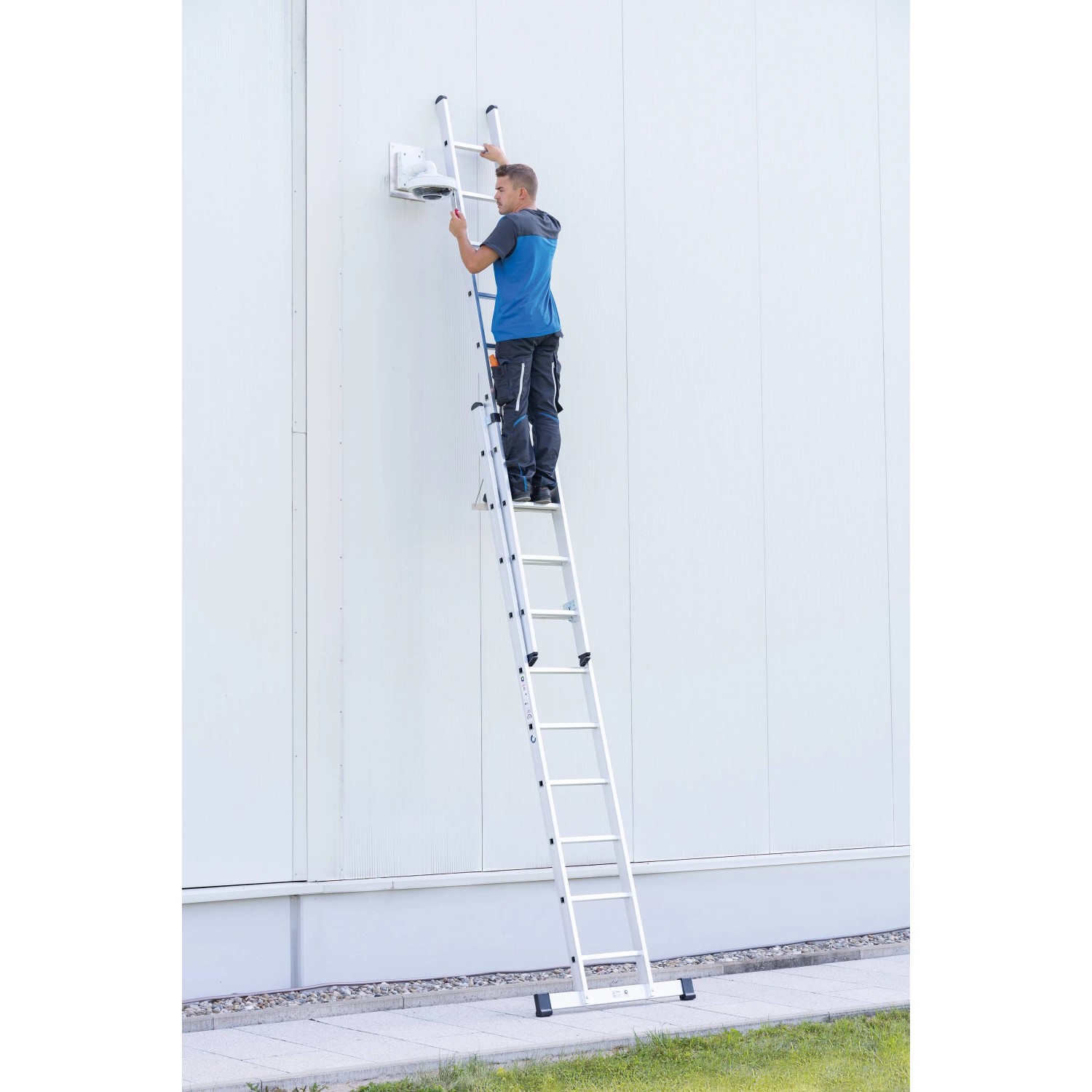 PROREGAL Sprossen-Schiebeleiter 2x14 Sprossen mit Traverse im Einsatz an einer Fassade.