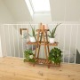 Braunes needs&wants Pflanzenregal Bloomy2 mit drei Ebenen und Pflanzen im Innenraum.