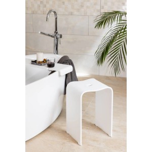 Weißer, matter Acryl Badhocker neben Badewanne. Moderner Duschhocker, freistehend, für Bad und Dusche.