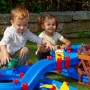 Kinder spielen mit AquaPlay WaterWheel Wasserbahn (53-teilig) im Garten.