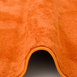 Detailansicht: Runder, orangefarbener Hochflor Teppich (Melia) von Pergamon, super soft und luxuriös.