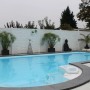 Weißer Betonzaun Romania (200x38,5x3 cm) als Sichtschutz am Pool im Garten.