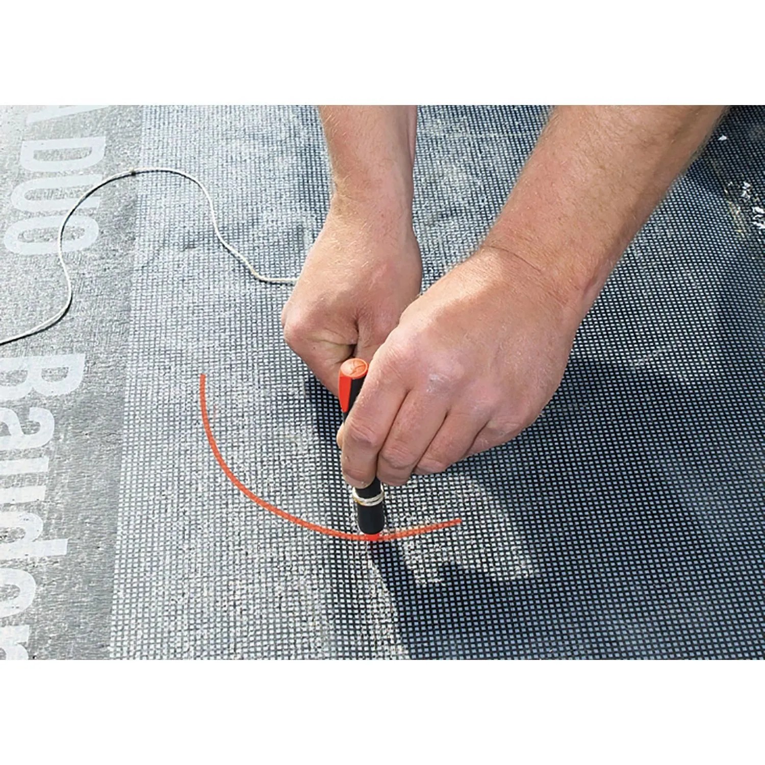 Hand markiert mit rotem Pica Visor 990 Permanentmarker eine Kurve auf dunklem Baumaterial. Präzises Messwerkzeug-Set.