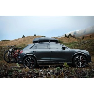 Graues Auto mit Atera Dachbox Casar M Lava 360 l Schwarz und Fahrrädern im Gebirge.
