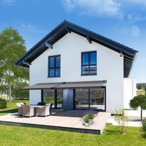 Anthrazitfarbene Home Deluxe LED Markise ELOS 500x300 cm am Haus mit Terrasse.