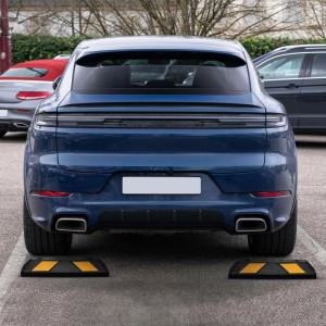 Zwei schwarze Gummi-Radstopper mit gelben Reflexstreifen hinter einem blauen Auto. Robuste Einparkhilfe für Garage.
