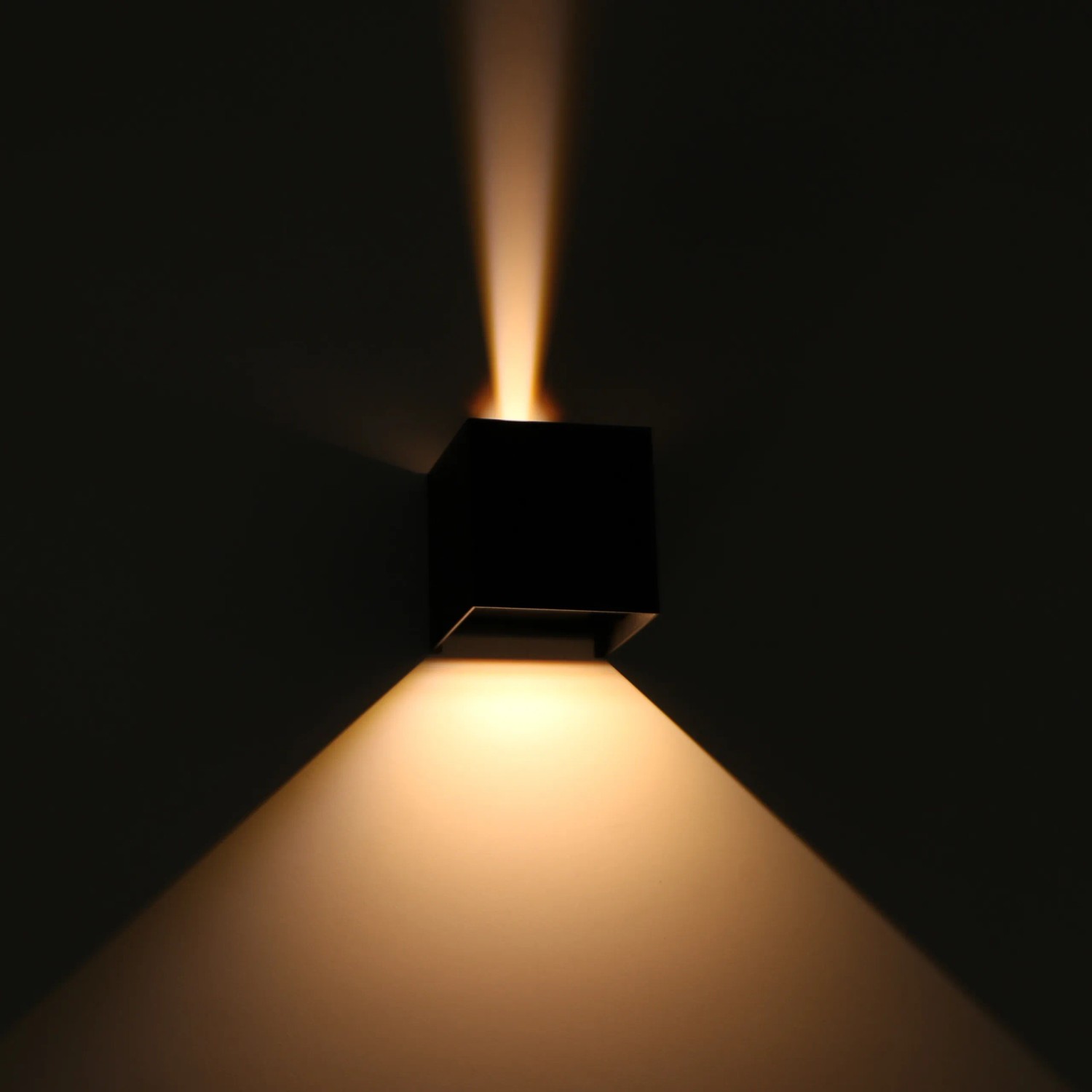 Schwarze, eckige LED Außenwandleuchte mit warmweißem Lichtkegel nach oben und unten.