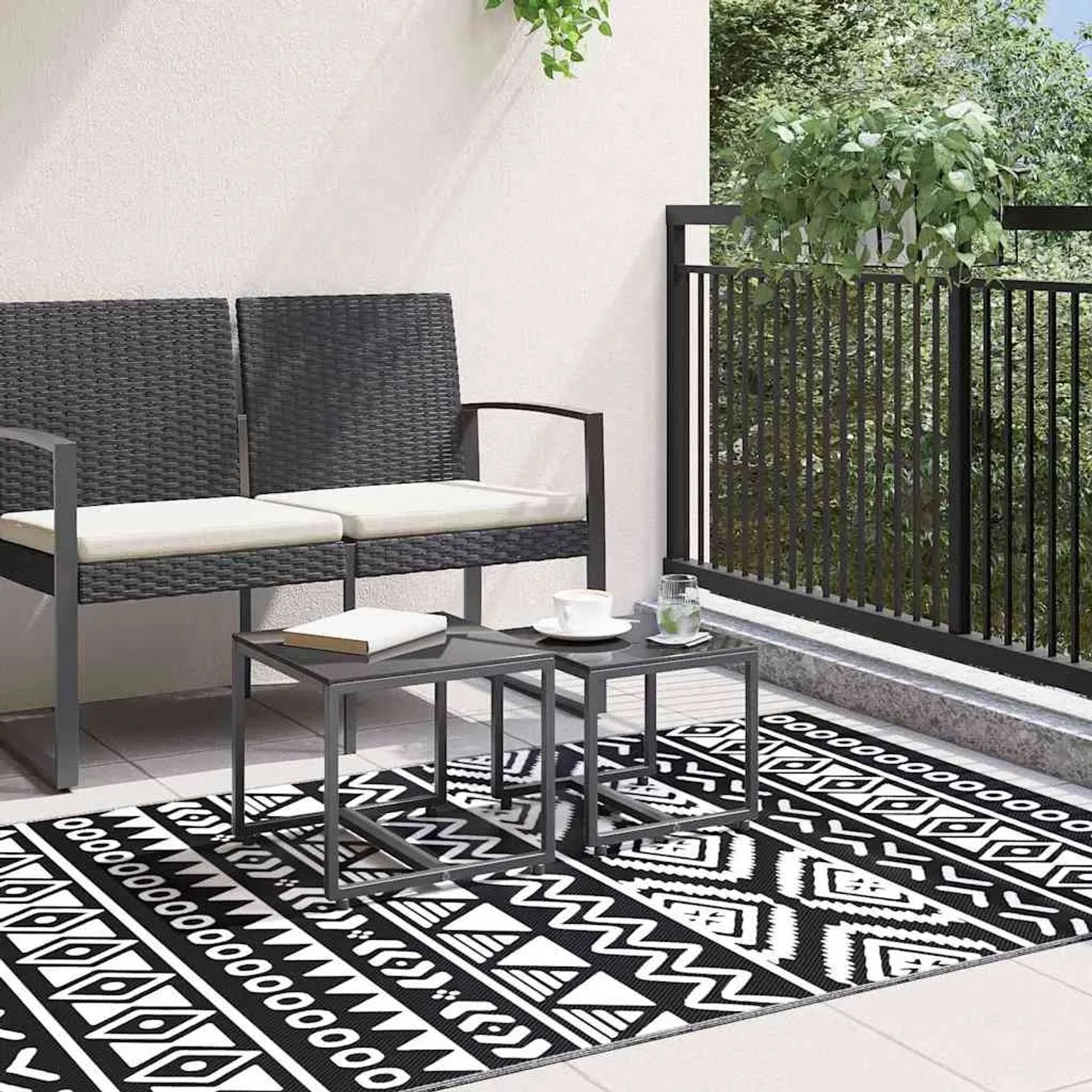 Schwarzer vidaXL Outdoorteppich (120x180 cm) mit grafischem Muster auf Balkon.