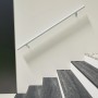 Weißer Minka Handlauf Sirius Wall 1,5 m an einer Treppe montiert.