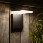 Schwarze, eckige Lutec Solar-LED-Außenleuchte Moze mit Bewegungsmelder an Holzwand.