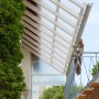 Transparente Acryl-Trapezplatte als Terrassenüberdachung mit Holzkonstruktion.