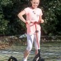 Mädchen auf rotem Six Degrees Aluminium Scooter mit Klappmechanismus und Ständer.