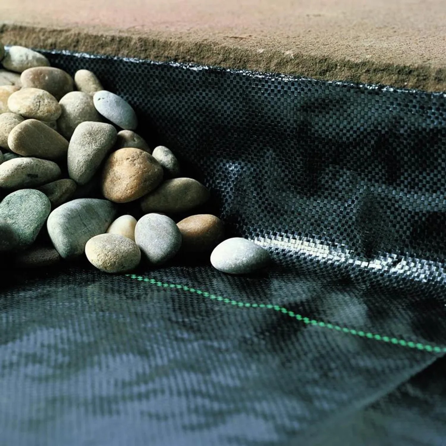Unkrautblocker Folie (1,0 m x 25 m) unter Steinen. Schutz vor Unkraut im Garten.