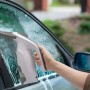 Akku-Fenstersauger im Einsatz zum Reinigen einer Autoscheibe für streifenfreie Sauberkeit.