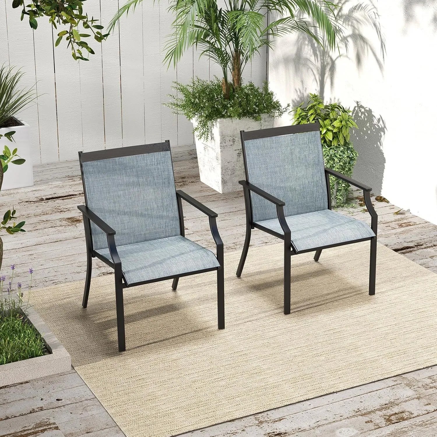Zwei blaue Terrassenstühle mit schwarzem Metallrahmen und breiter Sitzfläche auf einer Terrasse. Ideal für Outdoor.