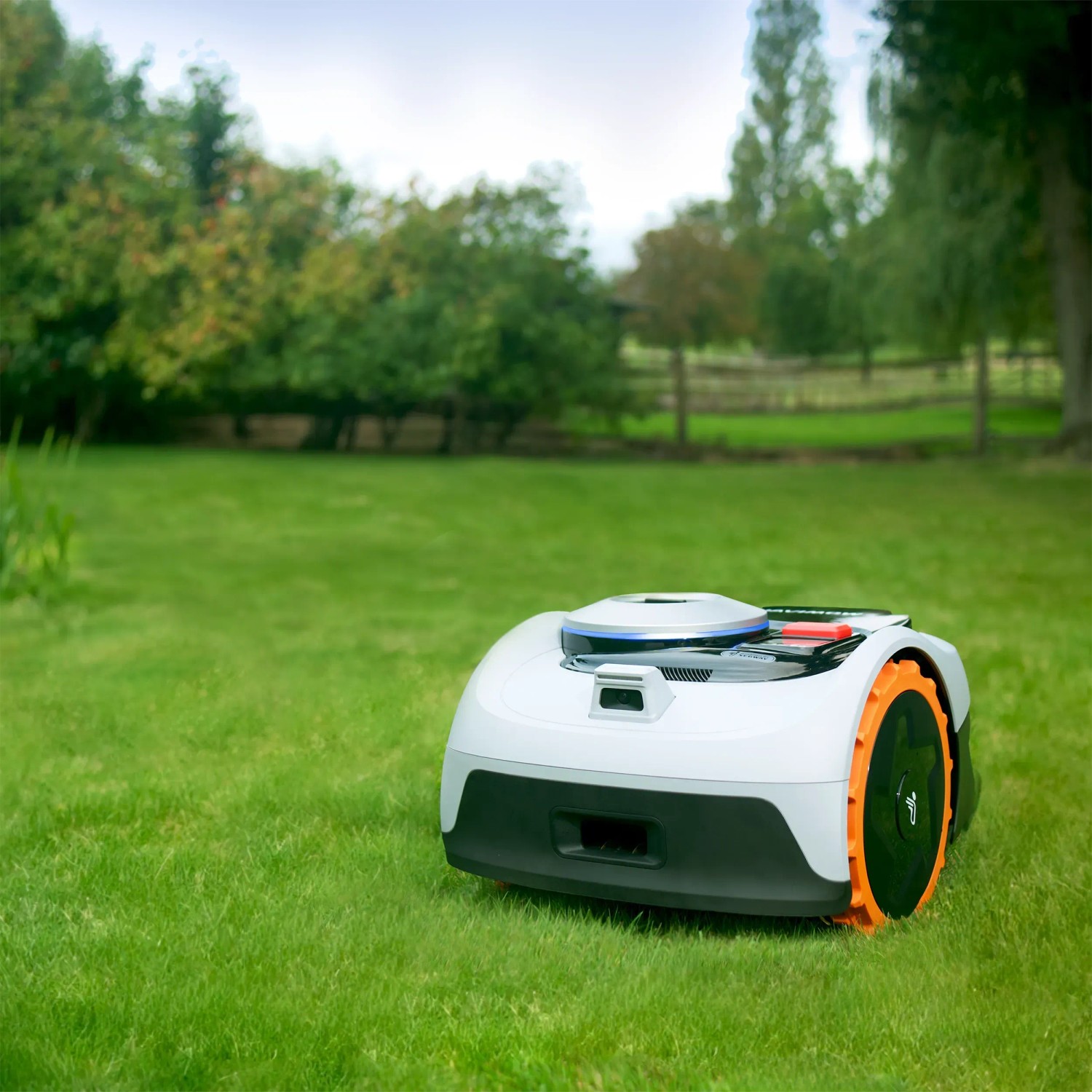 Segway Navimow Mähroboter i105E auf Rasen. Kabelloser Rasenroboter in Grau mit orangen Akzenten.