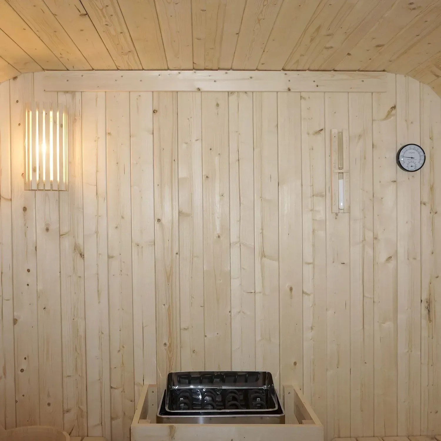 Innenansicht Artsauna Cube Fasssauna Nolvik XXL mit Ofen, Lampe, Thermometer und Hygrometer.