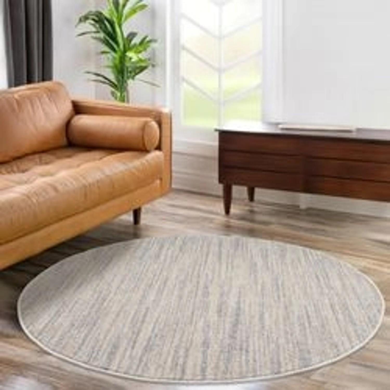 Runder, grauer payé Teppich Klassiko 52 mit Fransen, 160x160 cm im Wohnzimmer.